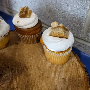 three cupcakes on a wooden board
