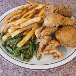 a plate of fried chicken, french fries, and green beans