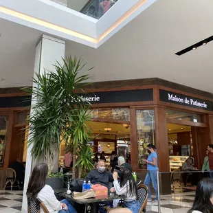 people sitting at tables in a mall