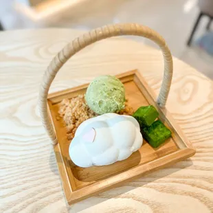 a wooden tray with a basket of treats on it