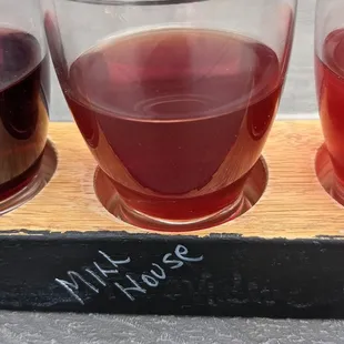 three glasses of wine on a wooden tray