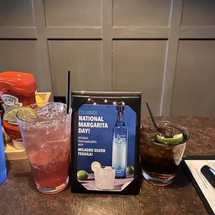 a glass of alcohol and a book on a table