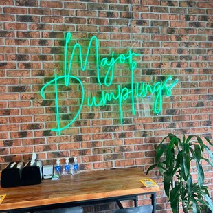 a neon sign on a brick wall
