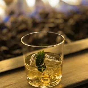 a glass of whiskey with a sprig of mint