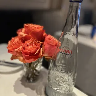 a vase of roses and a bottle of pepsi