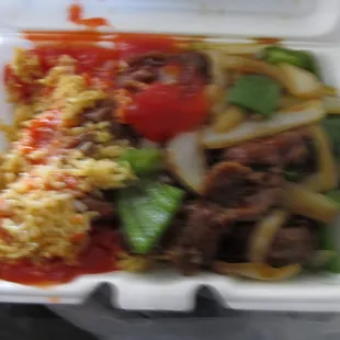 a very blurry picture of pepper steak with fried rice and "Mambo" sauce
