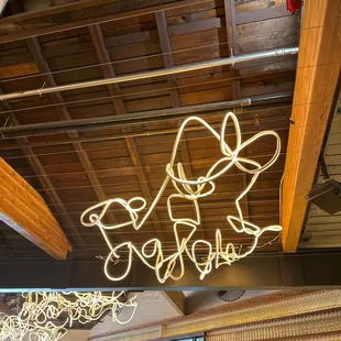 a neon sign hanging from the ceiling of a restaurant