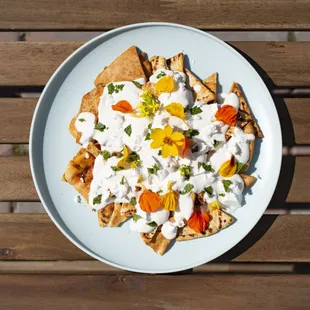 Syrian Fatteh: spice-toasted pita chips topped with feta cheese, garden herbs, and yogurt tahini sauce