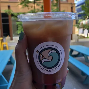 a hand holding a cup of iced coffee