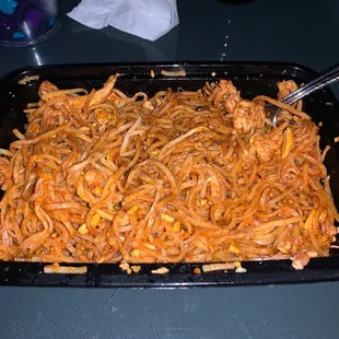 a tray of noodles with a spoon in it