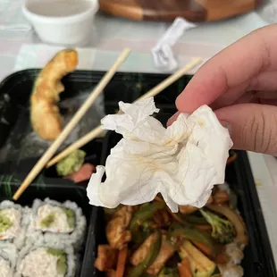a hand holding a piece of paper over a meal