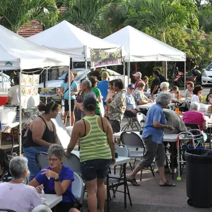 Folks enjoying the camaraderie of the neighborhood around tables provided by the church.