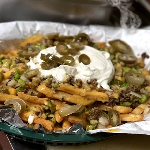 a plate of fries with sour cream and pickles