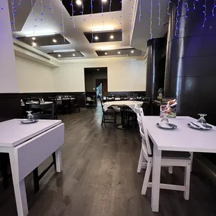 a dining room with white tables and white chairs