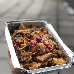 a hand holding a container of food
