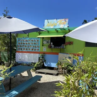 a food truck with tables and umbrellas