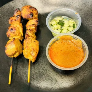 Chicken Satay with peanut sauce and diced cucumber.