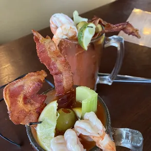 a bloody mug with bacon, shrimp, and pickles