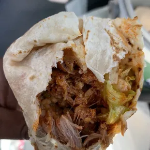 a hand holding a burrito