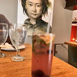 a woman sitting at a table with a drink