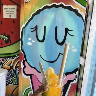 a hand holding a glass of orange juice