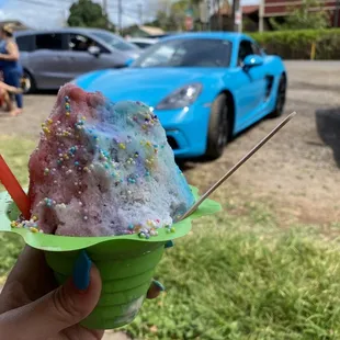 a hand holding a cup of ice cream