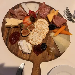 a platter of meat, cheese, and fruit