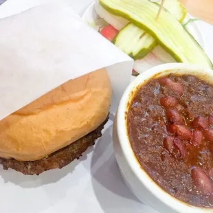 Hamburger with a cup of chili.