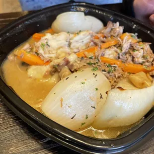 a bowl of stew with onions and carrots