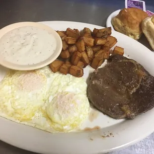 steak, eggs, potatoes and biscuits