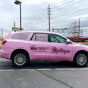 a pink car in a parking lot