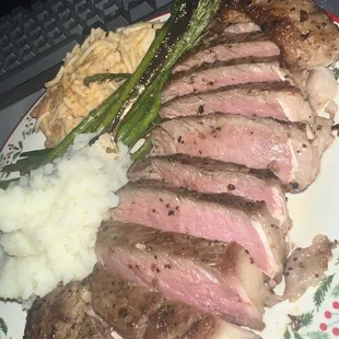 a plate of meat, mashed potatoes, and asparagus