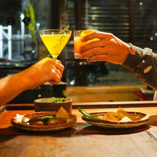 a man and a woman toasting at a bar
