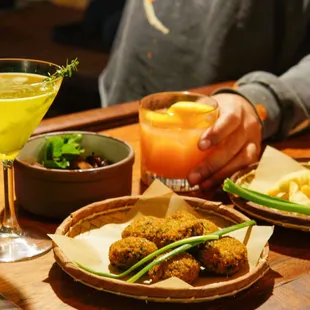 a person sitting at a table with food and drinks