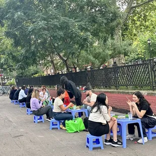 a group of people sitting on blue stools