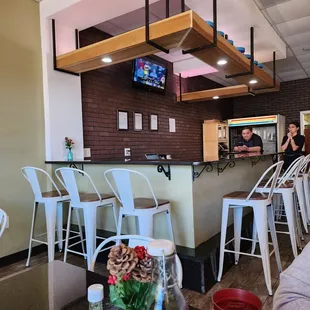 a view of a bar with white chairs