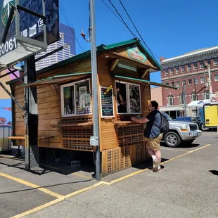 a man standing in front of a food stand