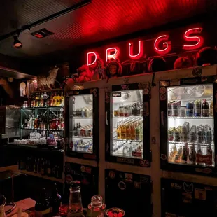 a neon sign that says drugs