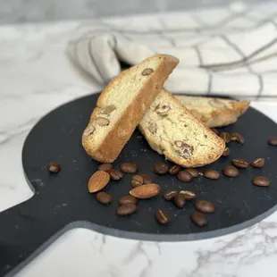 two pieces of biscotti on a plate with coffee beans