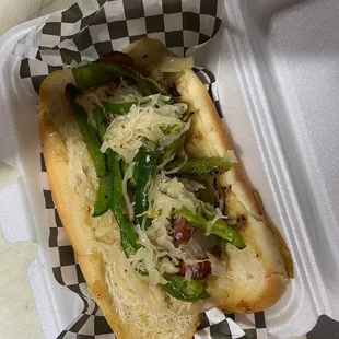 Kielbasa dog with, peppers, onions, sauerkraut on a hoagie bun