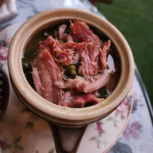 a bowl of soup with meat in it