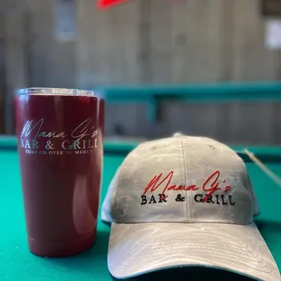 a cup and a hat on a pool table