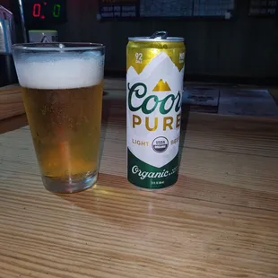 a can of beer and a glass on a table
