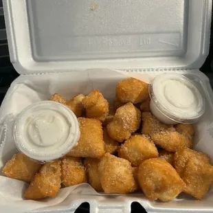 a takeout box filled with tater tots