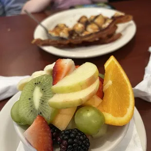 Fruit salad, with chocolate chip pancakes and crispy bacon