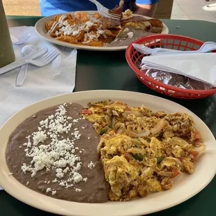 Spicy red chilaquiles on top and huevos a la Mexicana at bottom