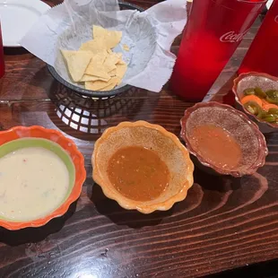 Set up - white cheese with chiles and tomatoes, spicy hot sauce, salsa and rellish.