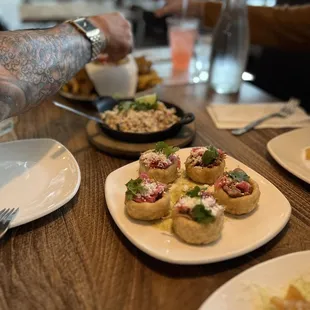 An assortment of Appetizers, street corn, ceviche, flautas....