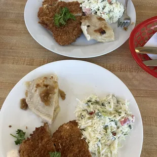 Two halves of a schnitzel meal with perogie and cabbage salad