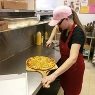 a woman cutting a pizza